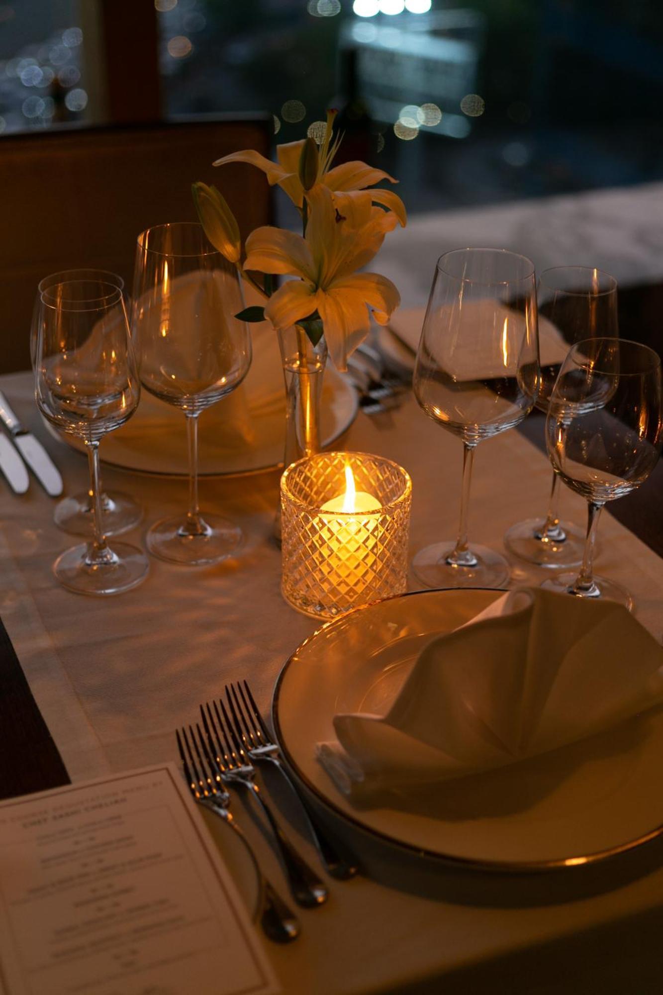 The Leela Ambience Gurugram Hotel & Residences - The Luxury Urban Sanctuary Ґурґаон Екстер'єр фото A candle on a dinner table