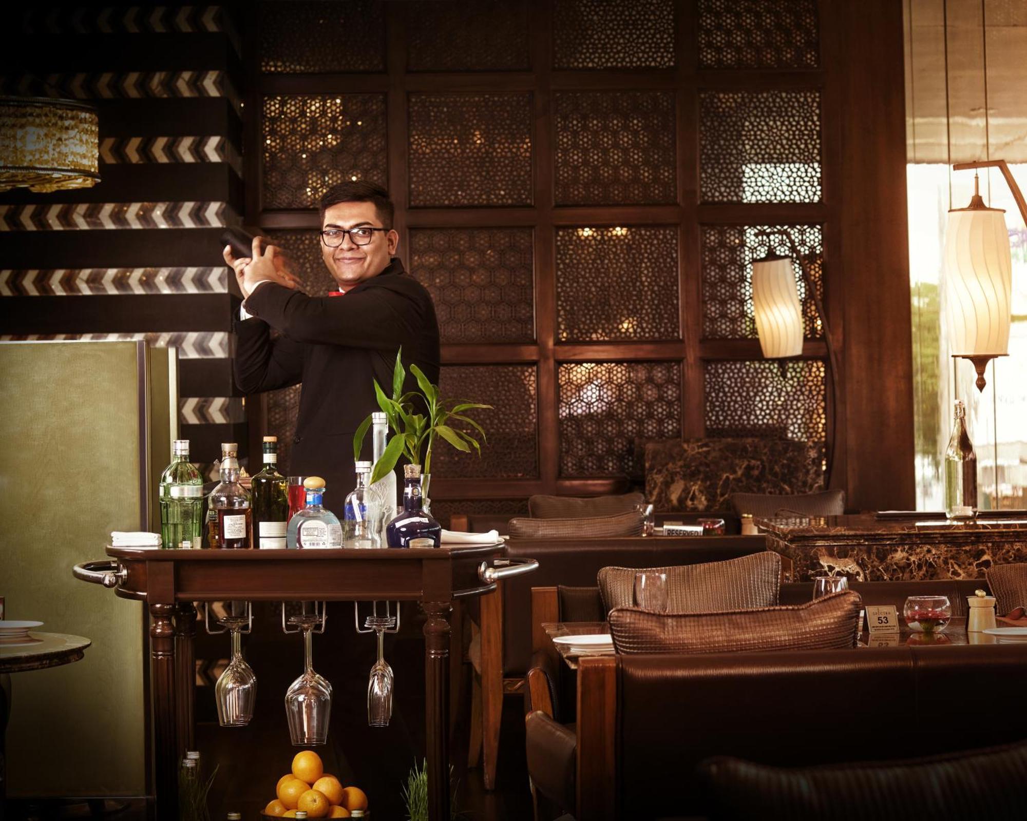 The Leela Ambience Gurugram Hotel & Residences - The Luxury Urban Sanctuary Ґурґаон Екстер'єр фото A bartender at work